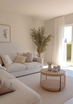 a living room filled with white furniture next to a large glass door leading to a patio