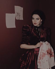 a woman in a red dress holding a white bag with blood all over her body