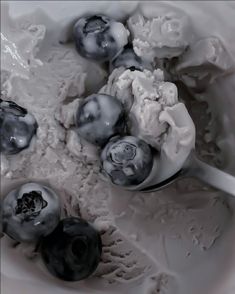 blueberries and ice cream in a bowl with spoons