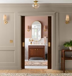 an open door leading to a bathroom with a vanity and mirror on the wall next to a table