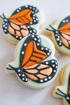 three decorated cookies with orange and black butterflies