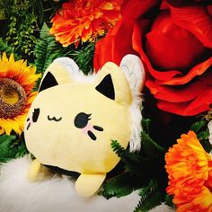 a stuffed animal surrounded by flowers and leaves