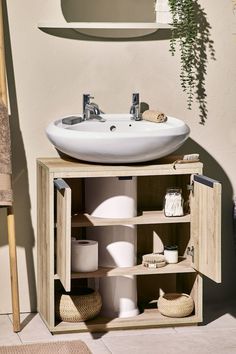 a white sink sitting on top of a wooden cabinet next to a wall mounted mirror