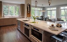 a large kitchen with an island in the middle and lots of windows on both sides