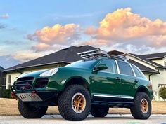 a green suv parked in front of a house