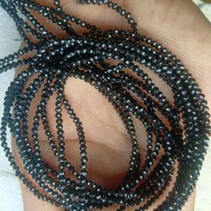 a hand holding several black beads in it's palm