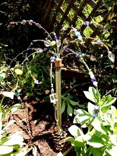 a garden with plants and flowers in the dirt near a wooden trellis on a sunny day