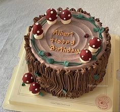 a birthday cake with chocolate frosting and mushrooms on it