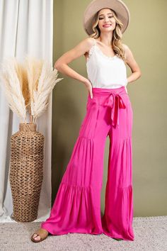 Wide leg pant with its tiered design with a smocked with a smocked waist and tie. (black available)rayon Chic Pink Tiered Bottoms, Tiered Skirt With Gathered Waist For Vacation, Tiered Bottoms For Summer, Solid Color Tiered Bottoms For Summer, Bohemian Tiered Bottoms With Elastic Waistband, Rayon Tiered Skirt For The Beach, Rayon Tiered Skirt For Beach, Casual Ruffle Bottoms In Rayon, Rayon Tiered Skirt For Day Out