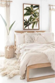 a bed with white sheets and blankets in a room next to a window, rugs and a potted plant