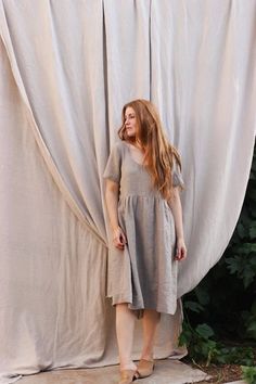 a woman standing in front of a white curtain