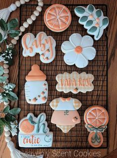 baby shower cookies on a cooling rack with flowers and greenery in the background for decoration