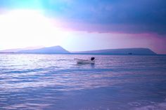 a small boat floating on top of a large body of water