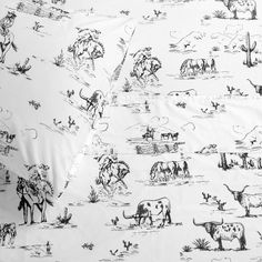 a black and white photo of cows in the wild on a sheet with an animal print