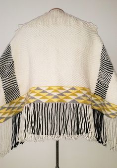 a white and yellow blanket with fringes on it