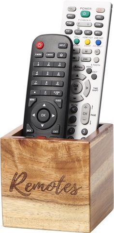 two remotes are sitting on top of a wooden box with the word remotes