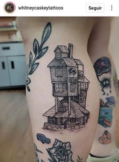 a woman's leg with tattoos on it and an image of a house in the background