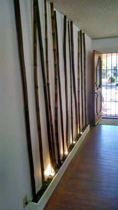 there are many lights on the wall in front of the door that is decorated with bamboo sticks