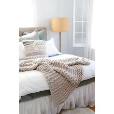 a white bed topped with pillows and blankets