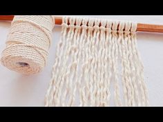 a close up of a piece of cloth with yarn on it next to a spool of wood