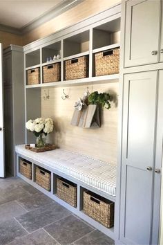 an entry way with baskets and flowers on the bench next to it is featured in this article