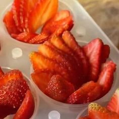 some strawberries are in small bowls on a table