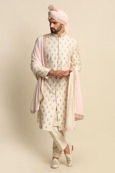 Ivory kurta with floral embroidered zardozi work butis. Paired with off-white kurta and churidar. Comes with an ombre stole, pagdi.
Component: 5
Pattern: Embroidered
Type Of Work: Floral motifs, Zardozi
Neckline: Mandarin collar
Sleeve Type: Full sleeves
Fabric: Raw Silk, Silk, Crepe
Color: White,Beige
Other Details: 
Side slits
Ombre stole
Embroidered motifs
Front button placket
Note: For juttis, please get in touch with the customer service
Occasion: Wedding, Destination Wedding - Aza Fashions Indian Wedding Clothes For Men, Embroidered Sherwani, Gents Kurta Design, Sherwani Groom, Gents Kurta, Zardozi Work, Sherwani For Men, Kurta Set For Men, Embroidered Motifs