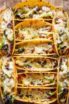 several tacos stacked on top of each other with cheese and toppings in them