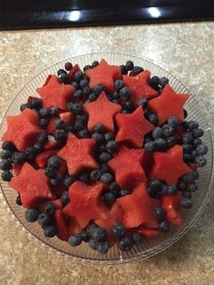 watermelon, blueberries and blackberries in a glass bowl on a counter