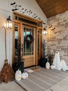 the front door is decorated for halloween with pumpkins and bats