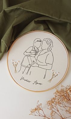 a couple is kissing in front of a green cloth and some dried flowers on the table