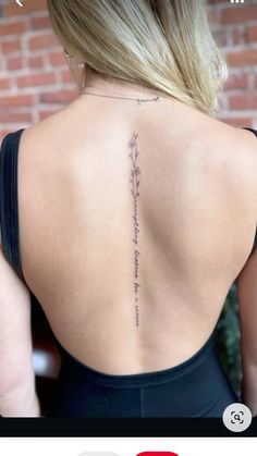 the back of a woman's neck with an inscription on her left side and flowers in