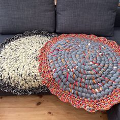 two round rugs sitting on top of a wooden floor next to a couch with pillows