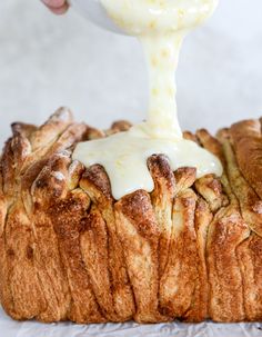 someone is spreading icing on top of a loaf of bread