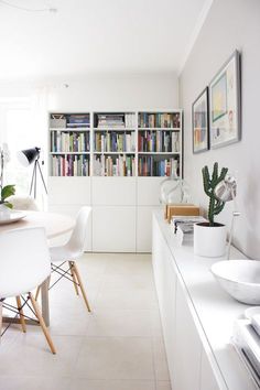 an image of a room with white furniture and bookshelves on the shelves in it