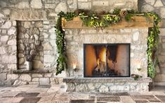 the fireplace is decorated with greenery and candles