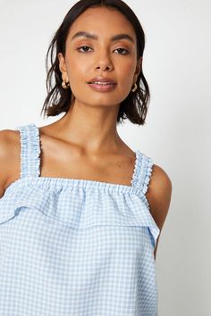 Gingham print woven top with a square neckline
Frill detailing along the neckline and straps
Sleeveless design with adjustable straps
Regular fit with a relaxed silhouette
Lightweight and breathable fabric for warm weather
This gingham print top from Dorothy Perkins exudes a charming, feminine vibe perfect for casual daytime occasions. The square neckline with frill detailing adds a playful touch, while the sleeveless design with adjustable straps allows for a customisable fit. Pair it with denim shorts or trousers for a stylish brunch ensemble or keep it breezy with a flowy skirt for family gatherings. The lightweight woven fabric ensures all-day comfort during warm weather. Frill Top, Frill Tops, Petite Coat, Gingham Pattern, Strappy Top, Cropped Vest, Tall Clothing, Top Trending, Blue Gingham