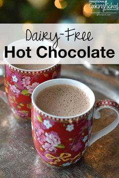 two mugs filled with hot chocolate sitting on top of a metal tray