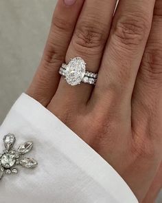 a close up of a person's hand with a diamond ring on their finger