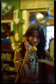 a woman talking on a cell phone while holding a banana