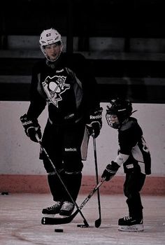 an ice hockey player and his son on the ice