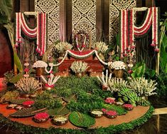 an elaborately decorated stage with flowers and greenery