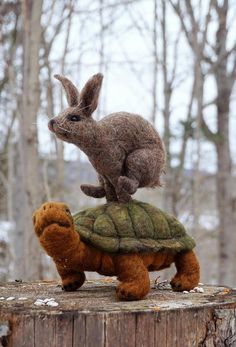 a stuffed rabbit sitting on top of a turtle