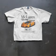 Elevate your racing style with FirstGear's McLaren F1 Classic White T-shirt. Crafted from premium 100% cotton at 180 GSM, this timeless fit tee pays homage to Formula 1 greatness. The crisp white front showcases the iconic McLaren Formula 1 logo, a bold tribute to racing excellence. Each shirt comes with a custom label, adding a touch of exclusivity to this collector's piece. True to size, it promises the perfect fit for every F1 enthusiast. This tee is the ultimate choice for your F1 Sundays, w Casual Short Sleeve T-shirt For Motorsport Events, Racing Style Crew Neck T-shirt For Streetwear, Racing Style Crew Neck T-shirt For Motorsport Events, White T-shirt With Motorsport Letter Print, White Racing Style T-shirt For Sports Events, White Letter Print T-shirt For Motorsport Events, Sporty Tops With Letter Print For Motorsport Events, Casual White Tops For Motorsport Events, Racing Style Letter Print T-shirt For Motorsport Events