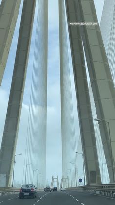 two cars driving on a bridge over water