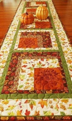 a table runner with pumpkins and leaves on it