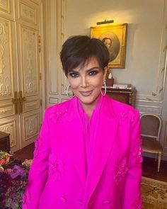 a woman in a pink suit posing for the camera