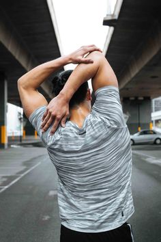 a man is stretching his arms on the street