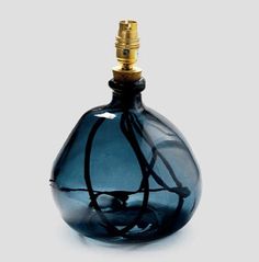 a blue glass bottle sitting on top of a white table next to a black object