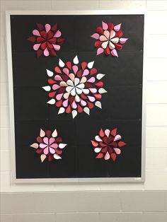 an art project with paper cut flowers on black and white background, hanging from the wall